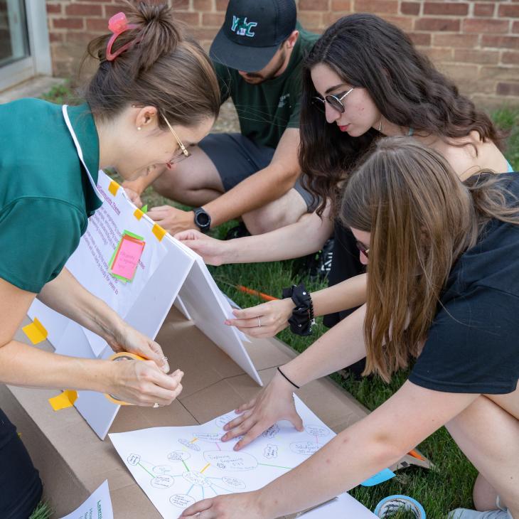Dr. Ashley Earle and students work outdoors on a thought-mapping exercise.