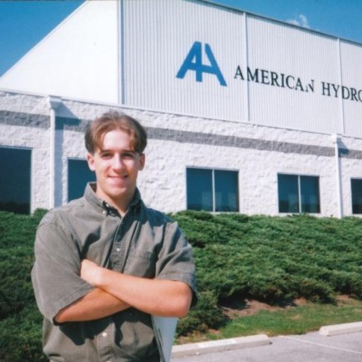 A photo from the 1990s shows Zack Stair posing in front of the American Hydro building.