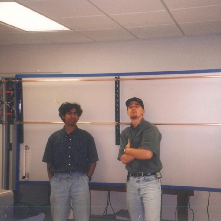 A photo from the 1990s shows two students posing for a photo in a lab classroom.