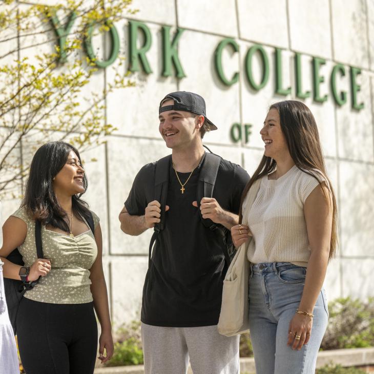 Four students stand in front of the York College sign