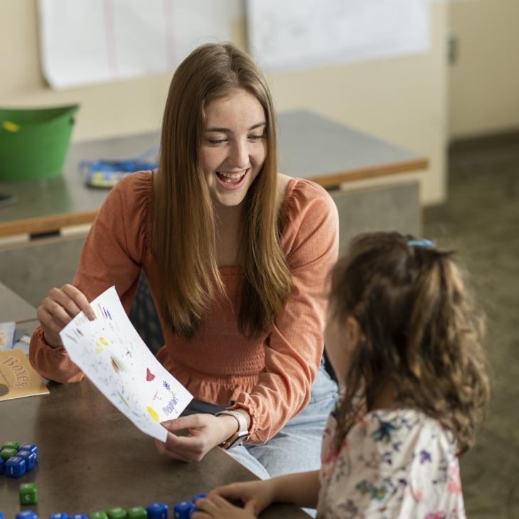A student teacher works with a young child