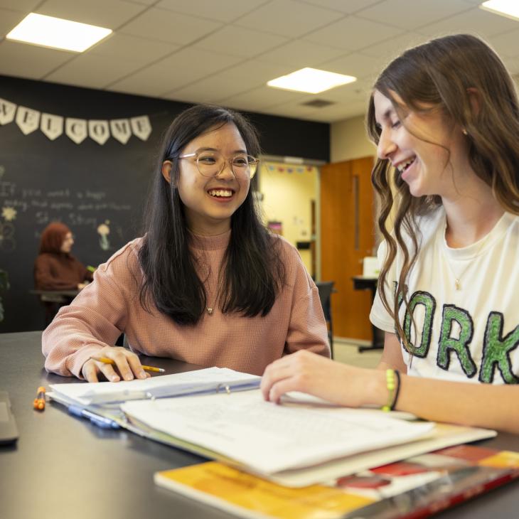 Peer tutor and student smile as they work together in the Academic Success Center.