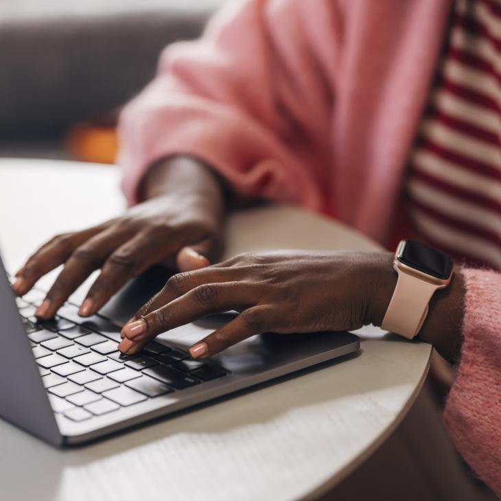 Close up shot of an anonymous woman typing on a laptop's keyboard.