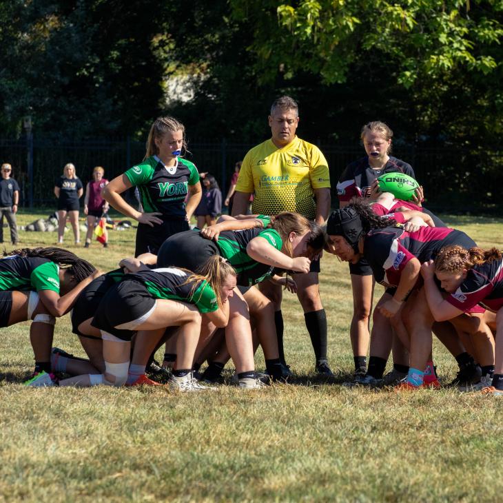 Women's Rugby players engaged on the field.