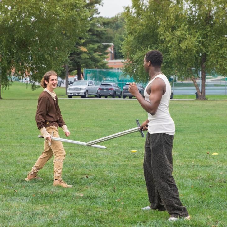 Two LARPers engaged in swordplay.