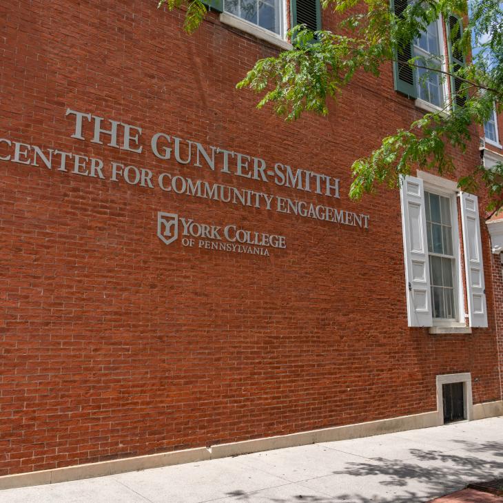 Side exterior of The Gunter-Smith Center building with a tree in the foreground.